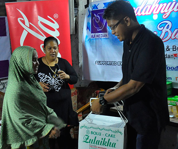 Ketua AJI Medan, Agoez Perdana (kanan) didampingi Sekretaris AJI Medan Fika Rahma (tengah), secara simbolis menyerahkan paket Ramadhan kepada perwakilan kaum dhuafa, pada acara silaturahmi dan buka puasa bersama keluarga besar AJI Medan, Jumat (17/6/2016).